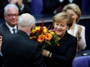 Angela Merkelnek (j) gratulálnak egy csokor virággal, miután nagy többséggel ismét kancellárrá választotta őt a Bundestag, a német törvényhozás alsóháza a parlament épületében, a be