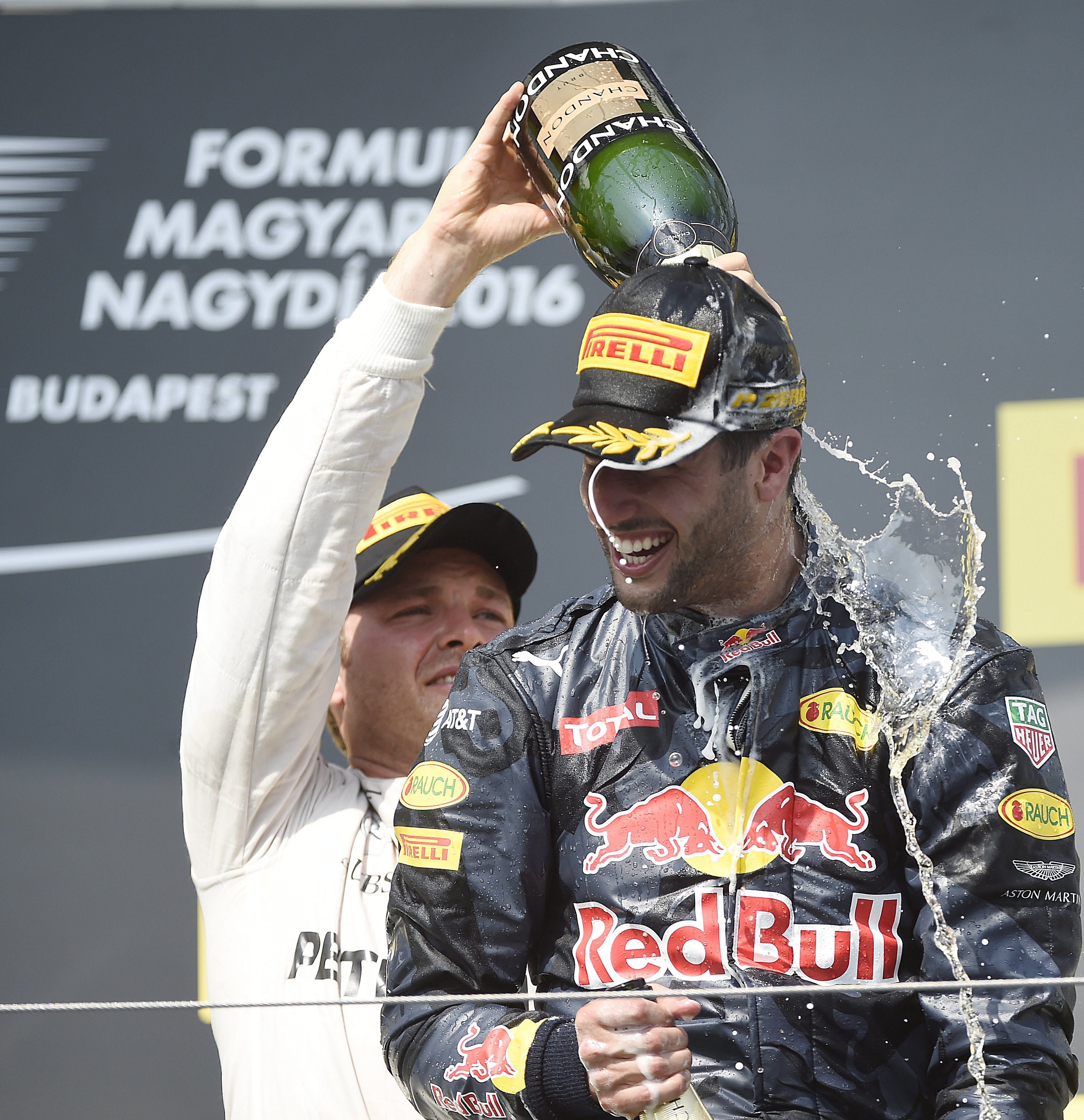 A második helyezett, német Nico Rosberg, a Mercedes (b) a harmadik helyen végzett, ausztrál Daniel Ricciardo, a Red Bull csapat versenyzője